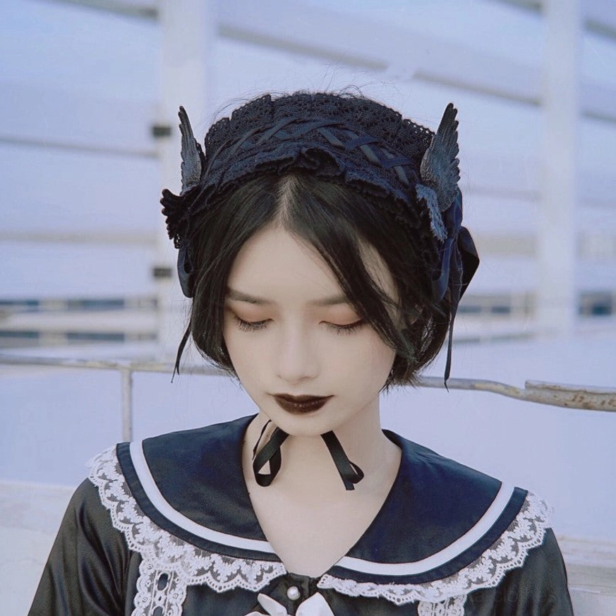 Gothic lolita hairband on model wearing sailor-style dress outdoor rooftop setting with black lace headband wing decorations and chin-fixed strap