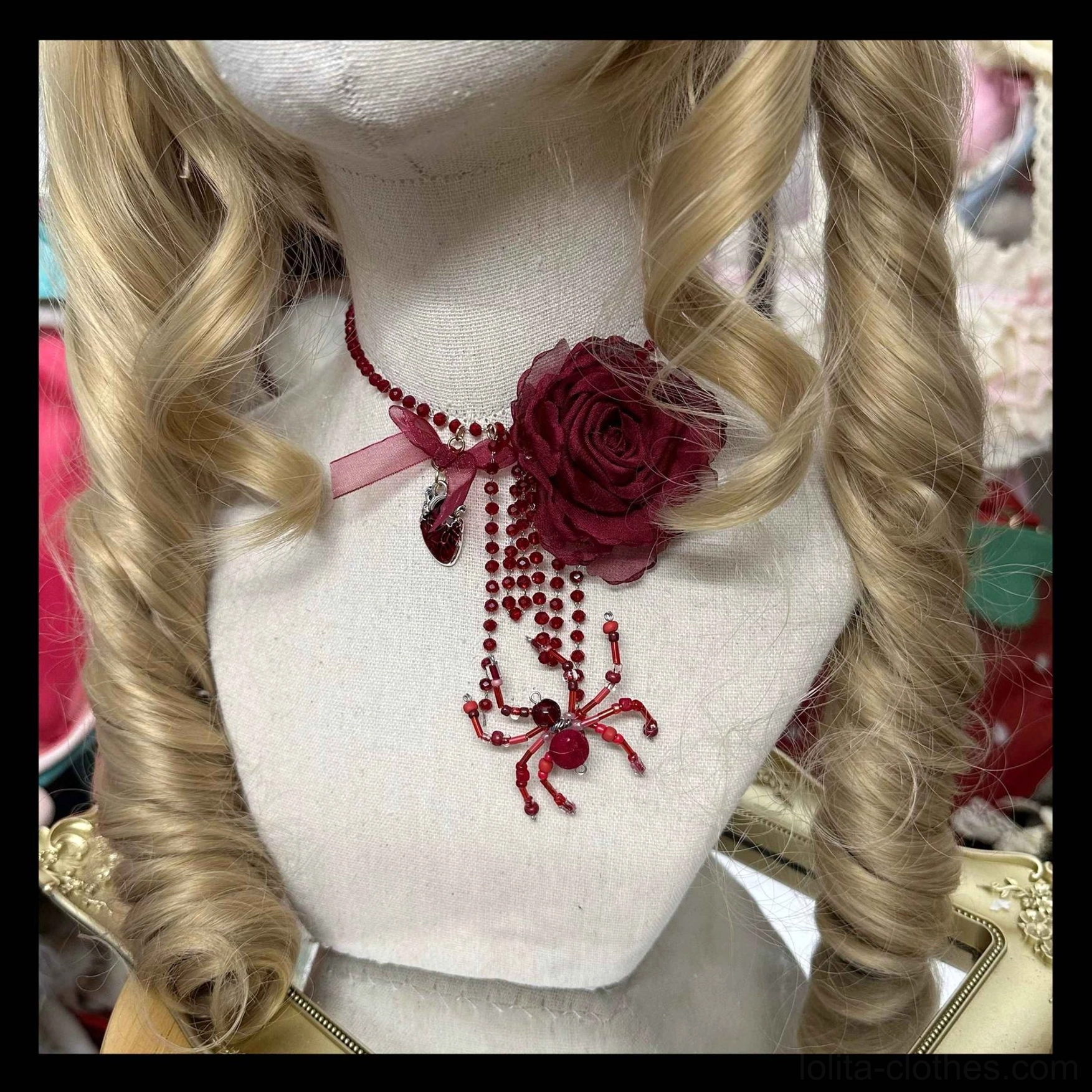 Gothic rose spider choker necklace worn on mannequin with wine red 3D rose and pink satin bow detail