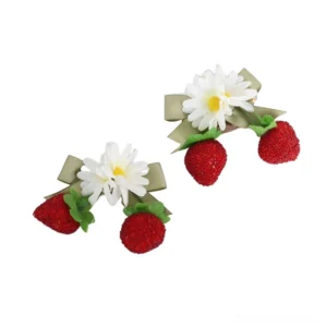 Grainy strawberry flower bow hair pins pair set on white background showing complete lolita hair accessory design with red textured strawberries and ribbon bows