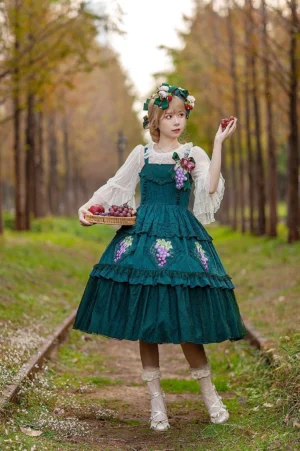 Dark green grape embroidery lolita JSK three-quarter view girl wearing flower wreath holding fruit tray autumn forest railway