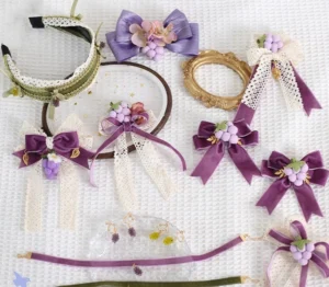 Complete grapery lolita accessory set flat lay featuring purple and green grape-themed necklaces, hair clips, earrings and brooches arranged on white fabric background