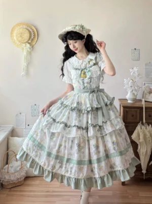 Grass green country lolita jumper skirt three-quarter view with matching floral print layered ruffled skirt and decorative collar brooch