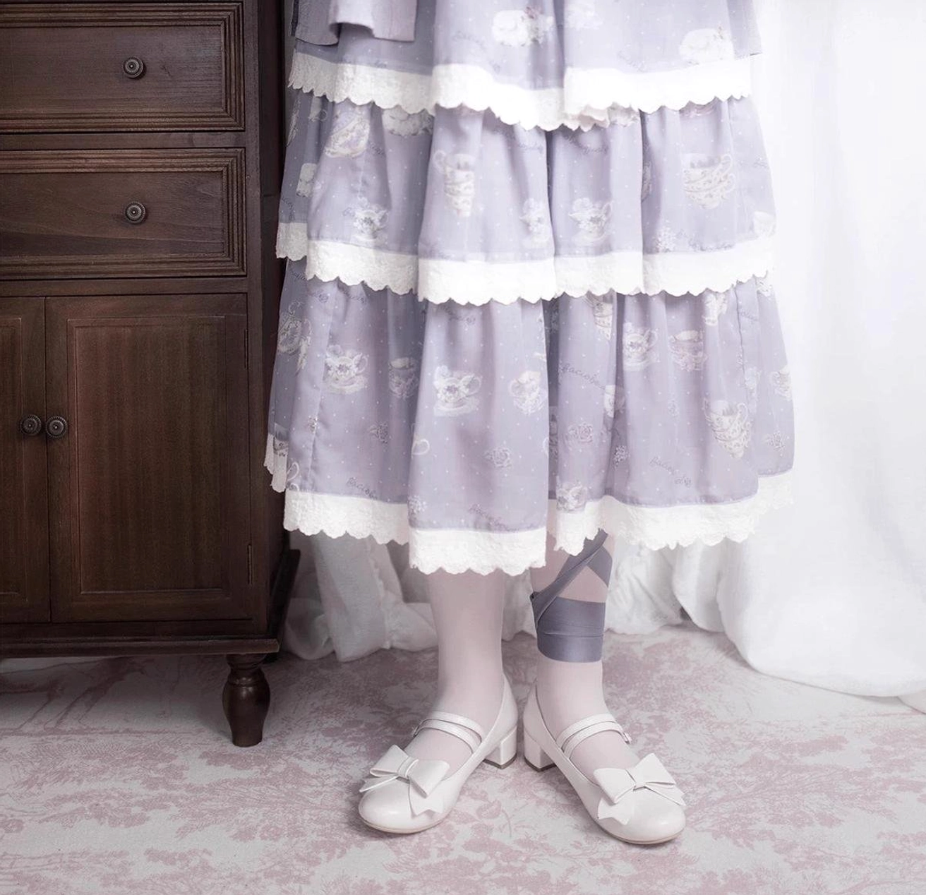 Gray Lolita Mary Jane shoes elegant pointed toe silhouette with ankle strap bow displayed overhead flat lay classic Lolita footwear design photography