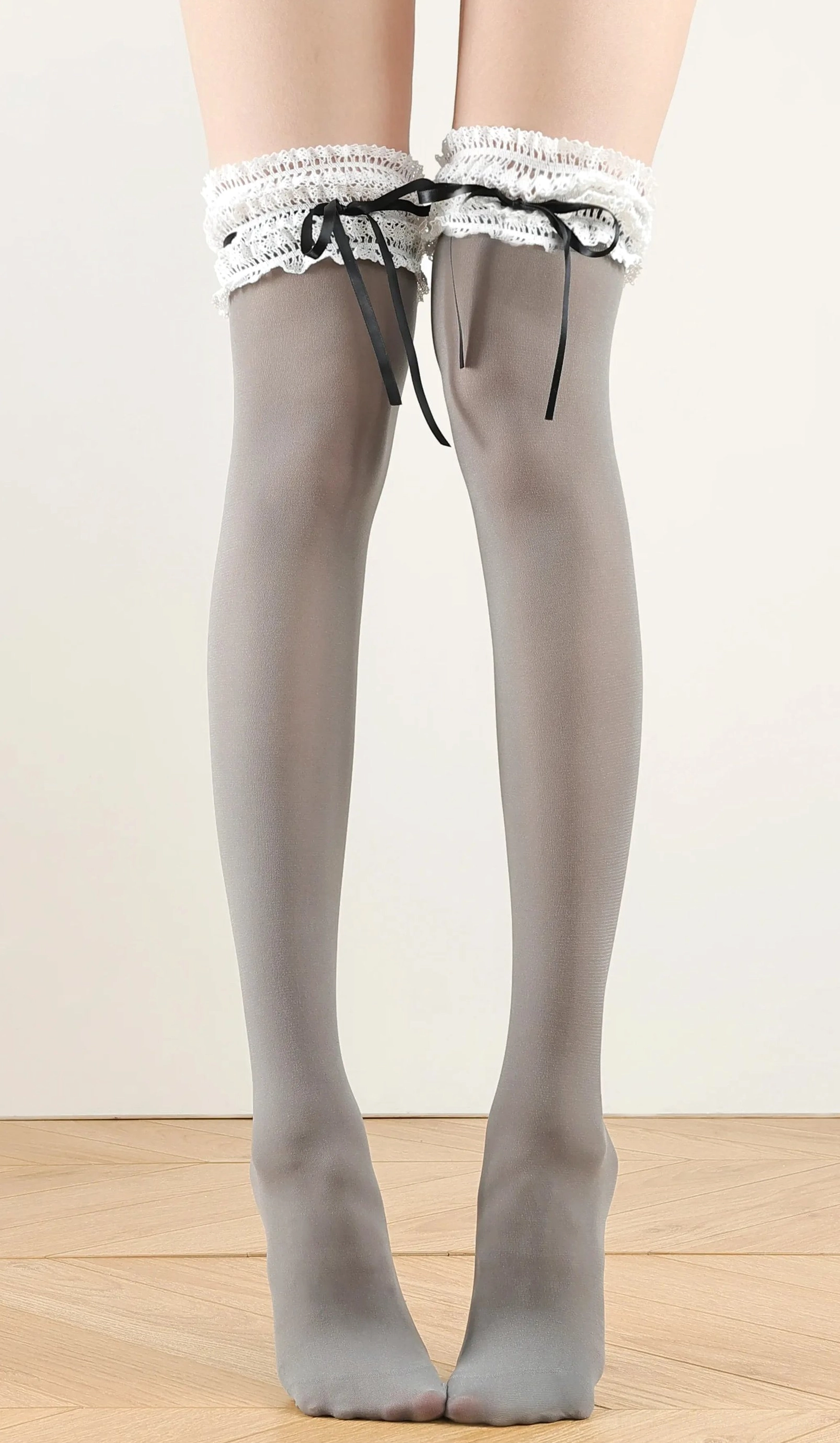 Gray over-the-knee classic lolita ruffle socks featuring frilled lace thigh cuff and satin ribbon bow, extended leg studio shot
