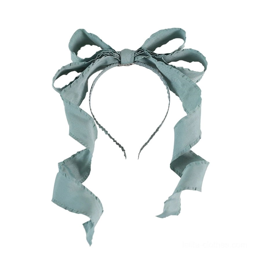 Sage green solid satin bowknot Lolita hair clip open-style headband with curled ribbon tails flat lay view