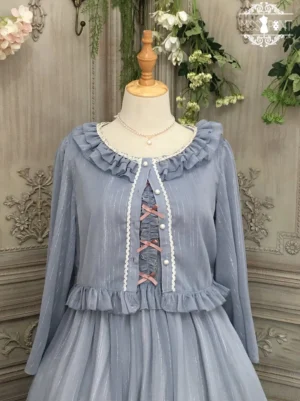 Grey blue lolita cardigan overlay with ruffled collar and shoulder details, pink ribbon lace-up front closure, and ruffled waist trim, displayed with matching jumper skirt dress in delicate striped chiffon, shown on mannequin with vintage wall decor