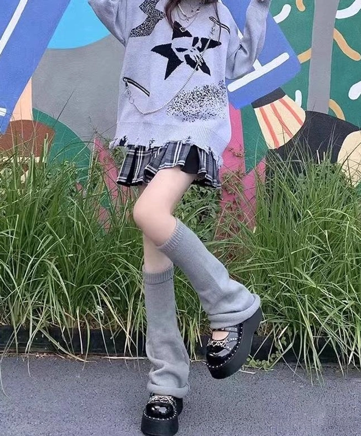 Grey loose fitting lolita leg warmers dynamic side angle with colorful mural green grass background distressed star print sweater