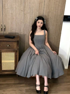 Grey plus-size lolita JSK dress suit with gathered pleated skirt and waist bow seated pose showing front details
