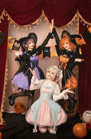 Halloween Gothic Lolita jumper dress group portrait high-angle shot featuring four models wearing pumpkin orange purple and pastel blue color variants with coordinating witch hats