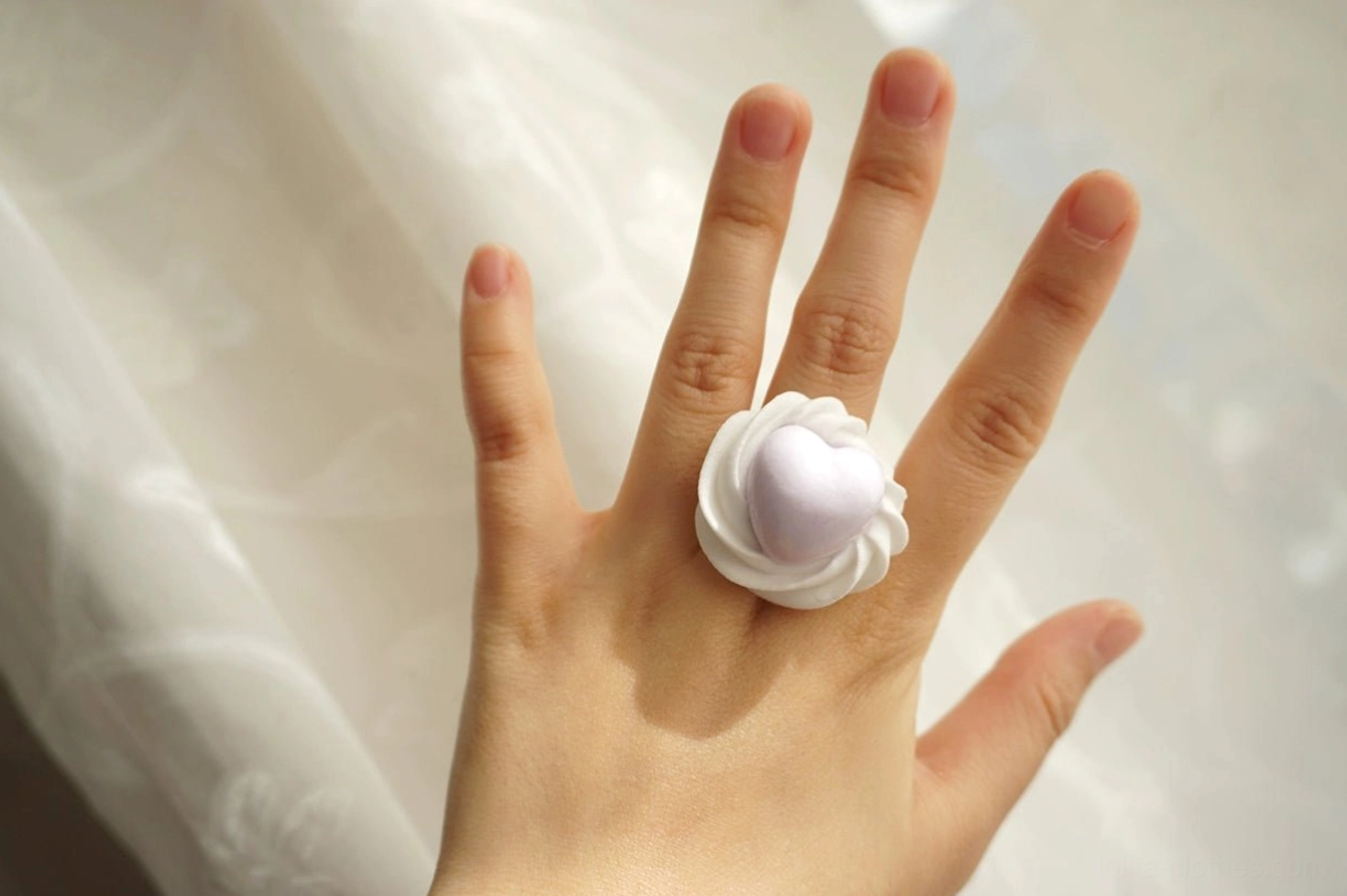 Purple handmade cream heart adjustable Lolita ring worn on hand showing the pastel heart and white cream effect setting