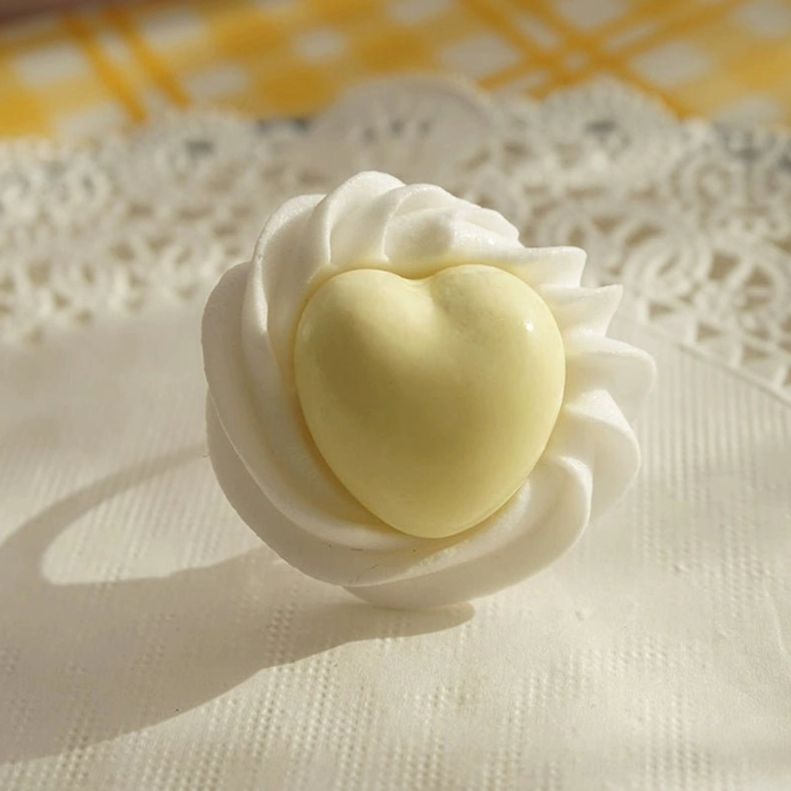 Yellow handmade cream heart adjustable Lolita statement ring close-up on lace placemat with checkered fabric backdrop