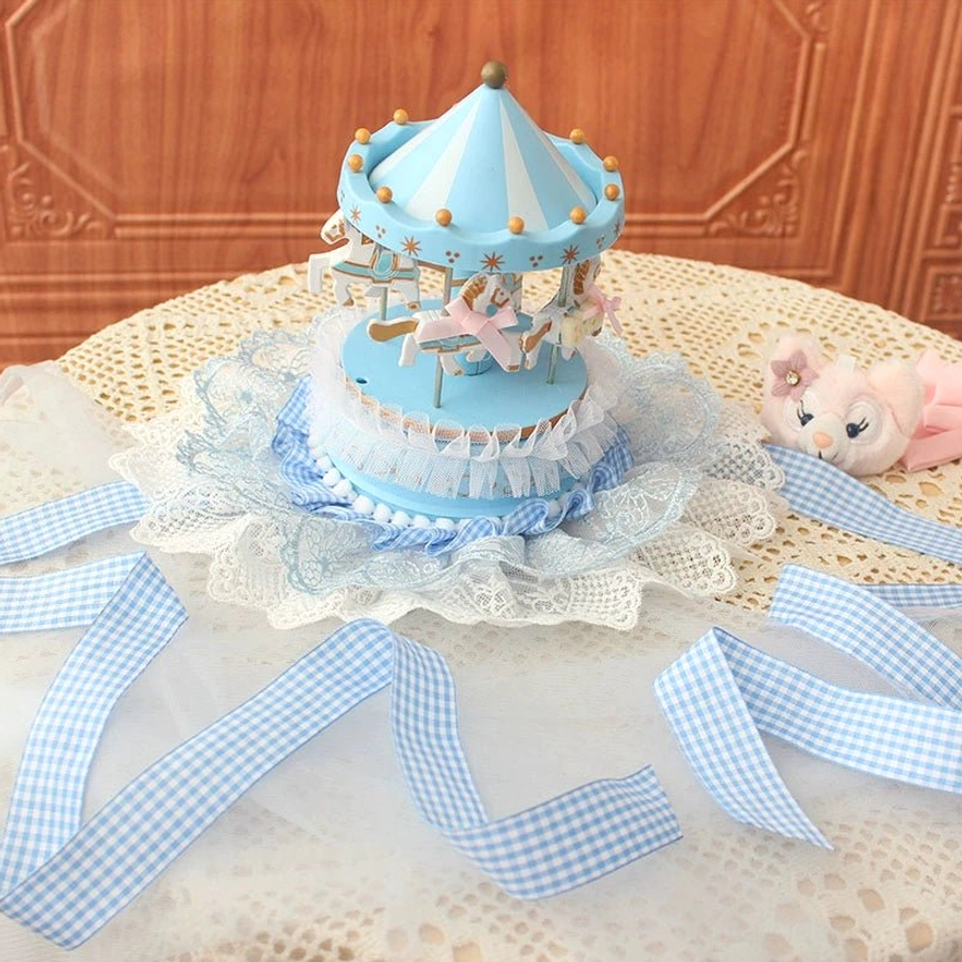 Sky blue lolita mini top hat oblique top-down view on crocheted lace mat showing pastel blue base and layered lace mesh frill decorations