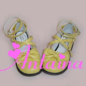 Handmade Lolita tea party shoes front three-quarter view bright yellow patent leather with toe bow crossover ankle straps heart buckles low block heel