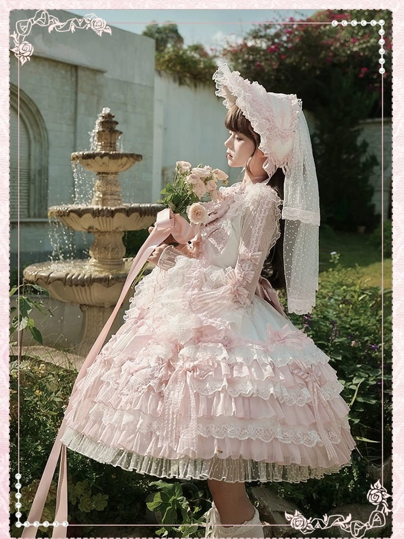 Sweet pink full lolita outfit with matching bonnet tulle veil tiered ruffled dress outdoor garden fountain