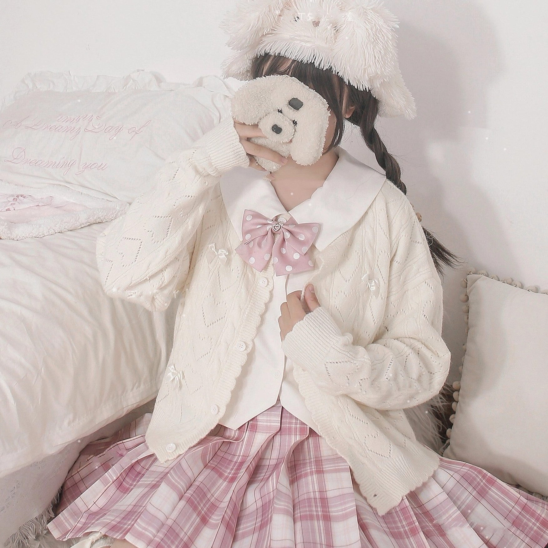Back view of hollow out Lolita cardigan showing heart-shaped cutout pattern across back, spreading bow details, and long sleeve construction