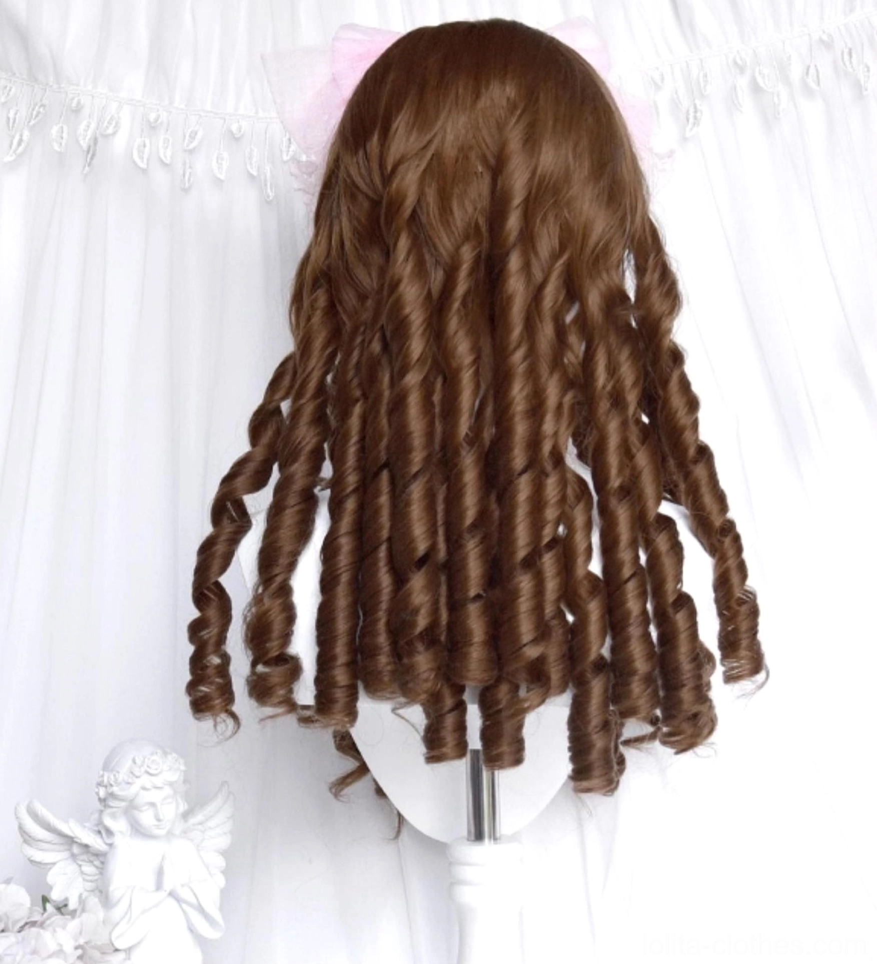 Back view of honey brown roman curl lolita wig displaying full-length spiral ringlets against white curtain with angel and flower decorations