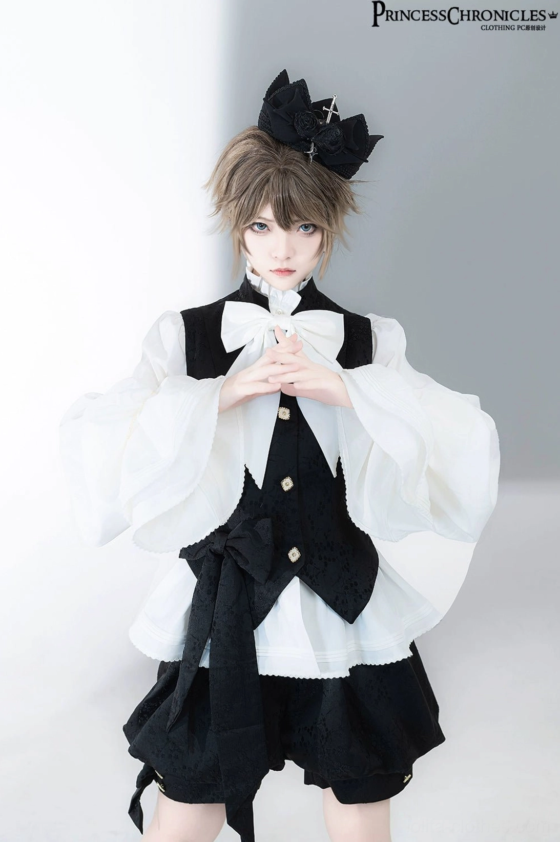 Close-up upper body front shot of vintage Ouji Lolita blouse displaying gold-tone waistcoat buttons, layered waist sash and oversized white bow tie