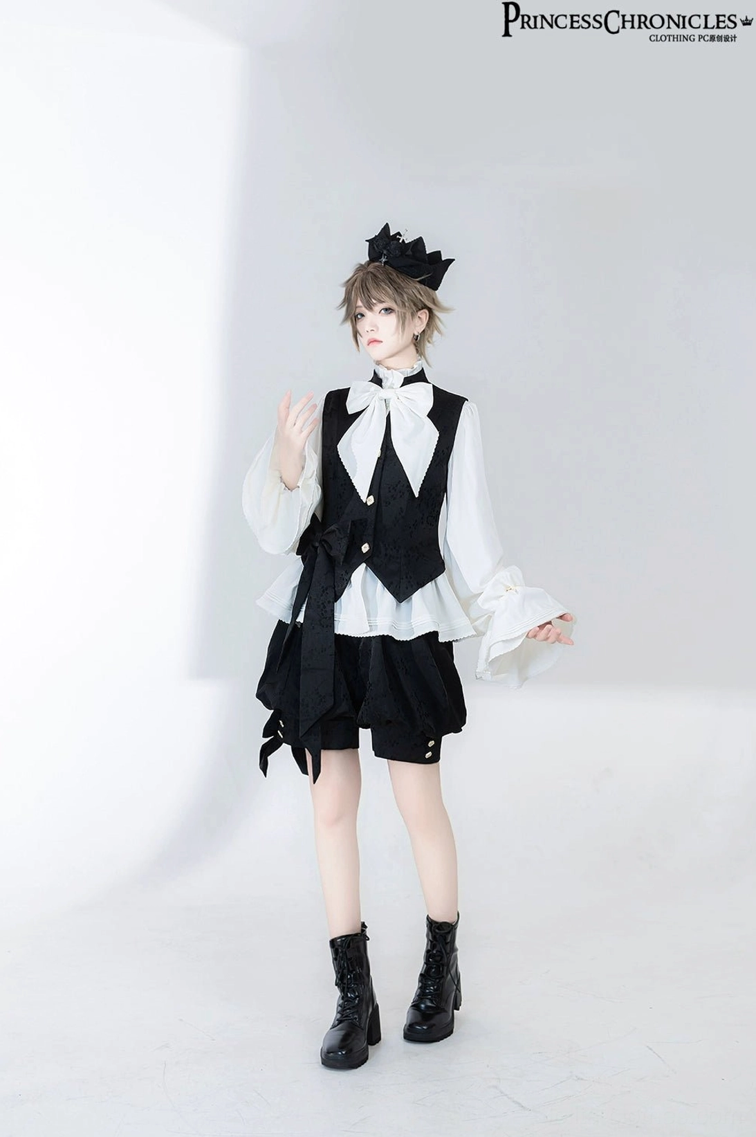 Full-body standing view of vintage Ouji Lolita prince shirt with slim-fit waistcoat, neat short black bloomers and crown-style bow hairpiece