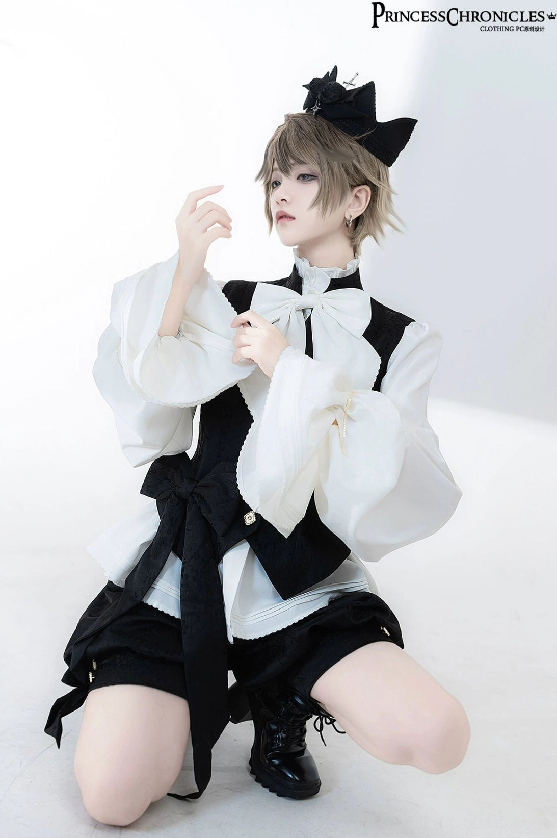 Half-body kneeling shot of vintage Ouji blouse with detachable white bow tie and structured tailored waistcoat featuring decorative buttons