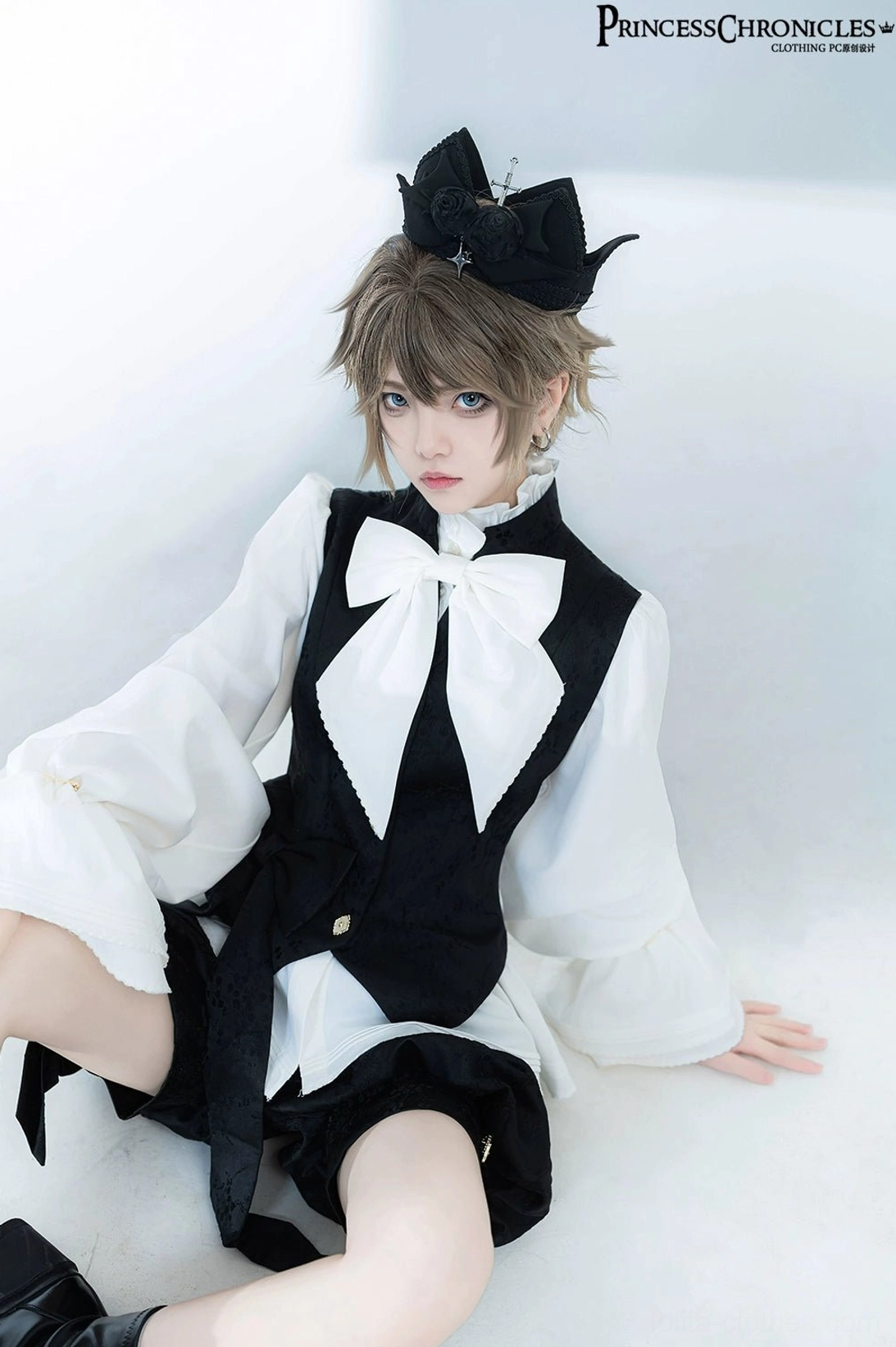 Half-body sitting front shot showing close-up detail of Ouji prince upper outfit, large satin bow tie and waistcoat button embellishments