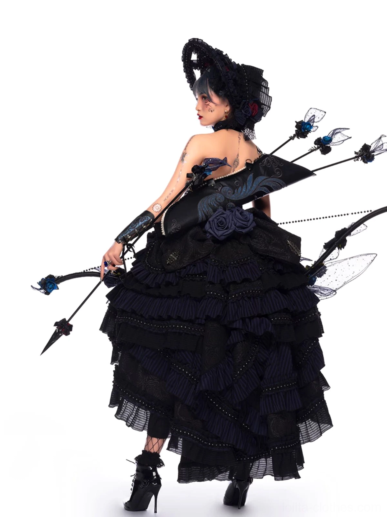 Gothic Lolita JSK tiered ruffled hem layers detail closeup showcasing high-low skirt structure, multiple ruffles, lace edging, dramatic silhouette construction