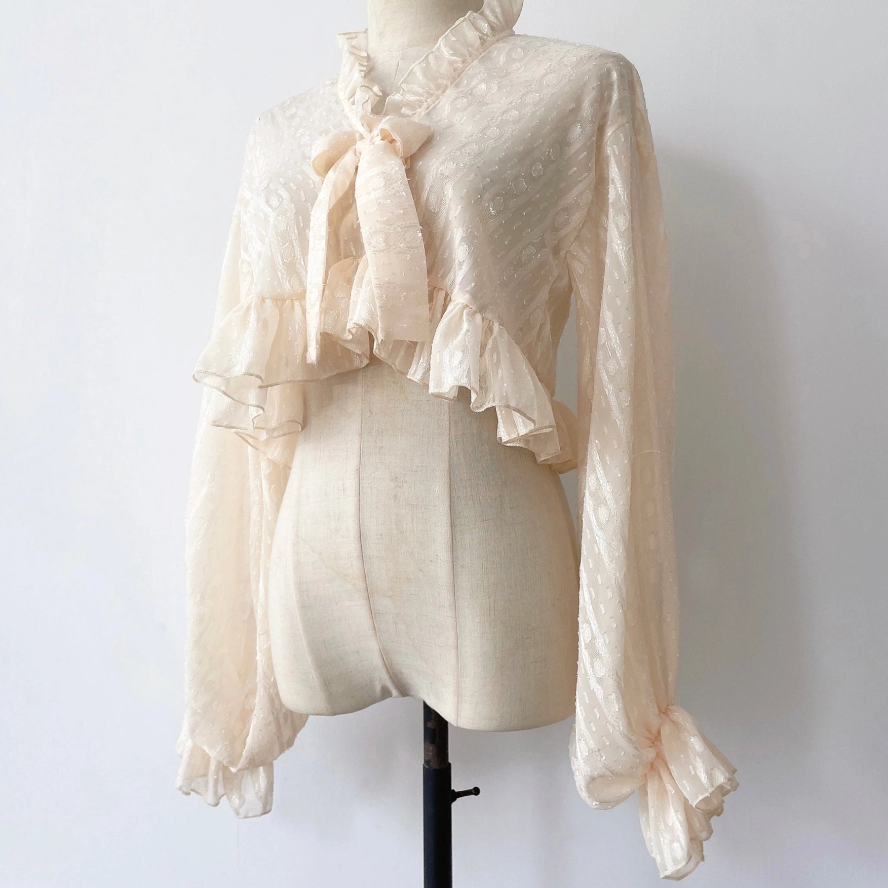 Beige apricot ivory sheer jacquard chiffon puff sleeve Lolita cardigan with removable bow tie on dress form front view