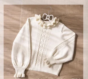 Ivory cable knit lolita sweater with double-layered ruffled stand collar and puff sleeves displayed on wooden hanger, flat lay overhead view showing intricate diamond knit pattern and delicate ruffle details
