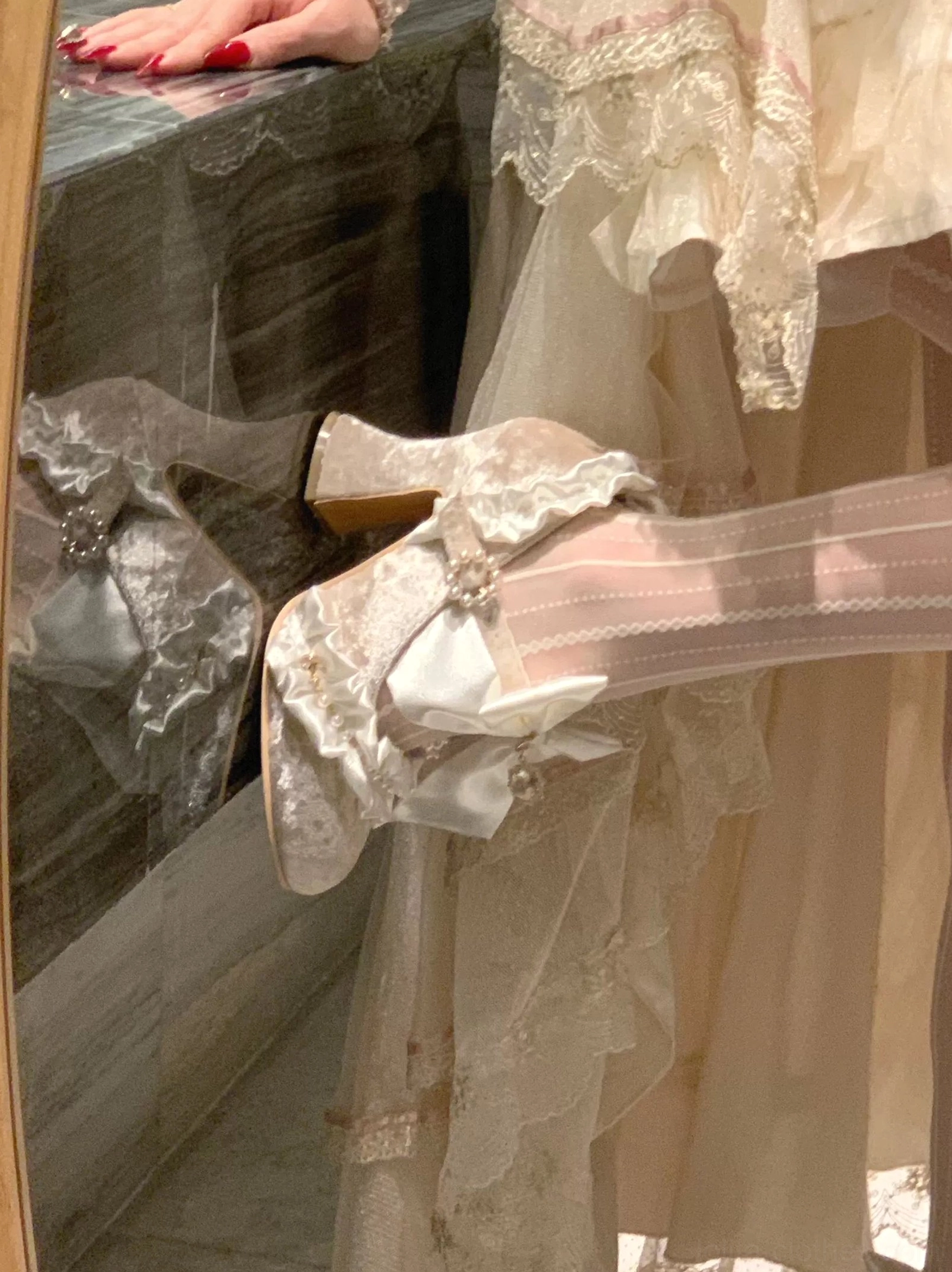 Ivory Classic Lolita heel shoes with satin bow and pearl ankle strap, close-up side view on glass countertop with delicate lace trim detail and vintage lace dress styling