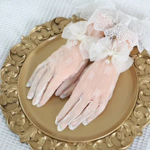 Ivory vintage lace Lolita gloves with sheer floral pattern and delicate pearl-adorned bowknot gauze decoration on elegant gold decorative tray