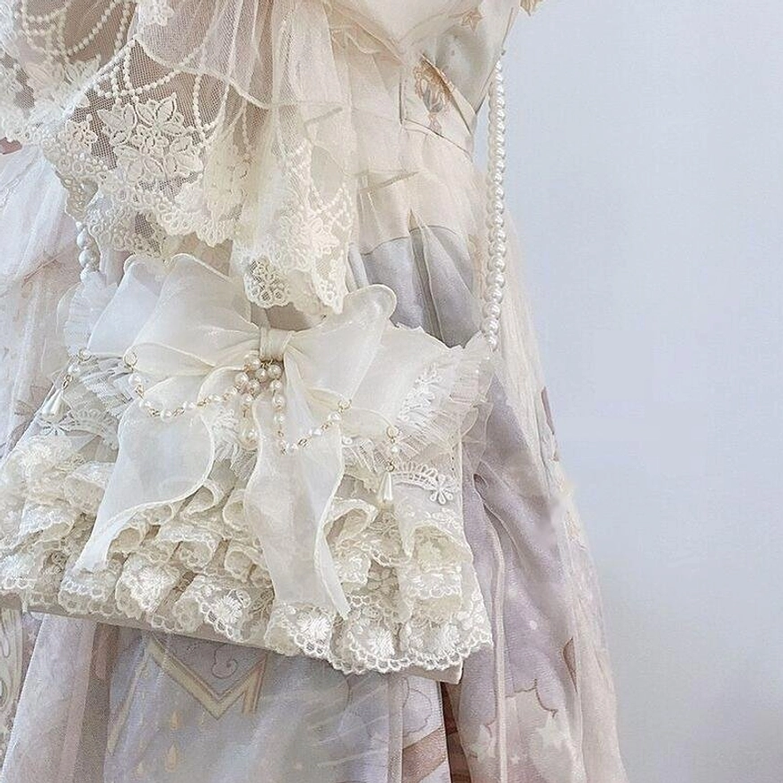 Ivory lolita handbag styled with sweet lolita dress showing bow and lace decoration coordination on lace bodice