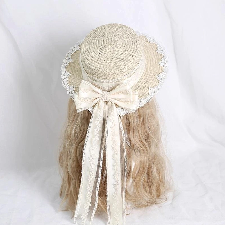 Ivory handmade lolita lace straw hat rear three-quarter view showing dome-shaped crown, scalloped lace-trimmed brim, ornate side embroidery, and detachable lace bow with flowing ribbon sash