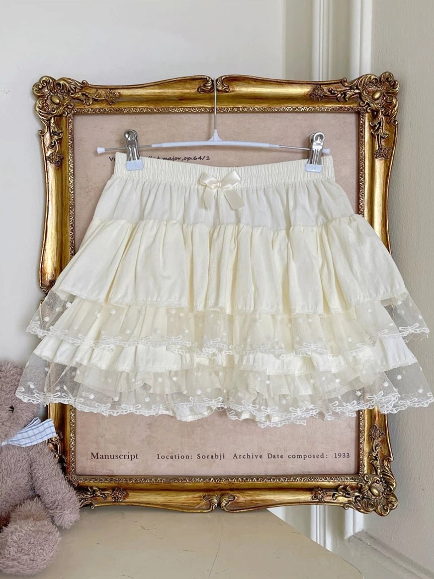Ivory Lolita ruffle bloomers hanging display on golden vintage frame showing tiered multi-layer ruffles delicate polka dot lace hem tiny elastic waist bow and elegant vintage aesthetic setting