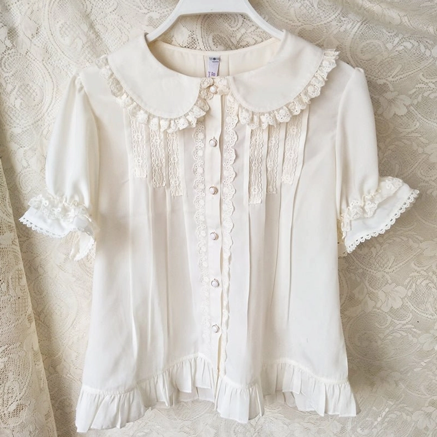 Ivory Peter Pan collar sweet lolita blouse hung on hanger front view displaying ruffled lace collar puffed sleeves lace cuffs and pearl button placket