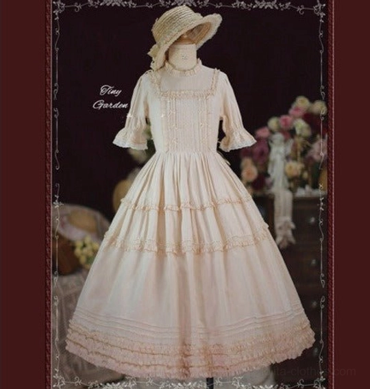 Cream ivory square collar pin tucks vintage lolita OP dress front view on mannequin with detailed bodice pin tucks and tiered ruffle skirt indoor flower background