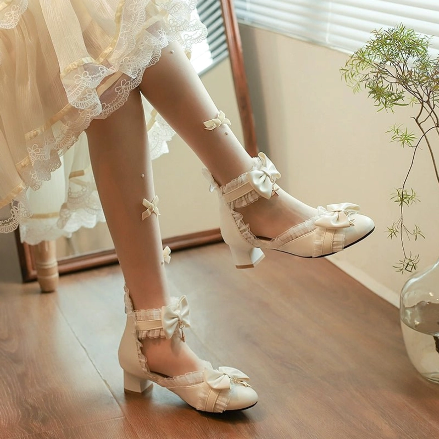 Ivory Sweet Lolita Mary Jane shoes with star charm bow and ruffled ankle strap on model in beige ruffled skirt with wooden backdrop