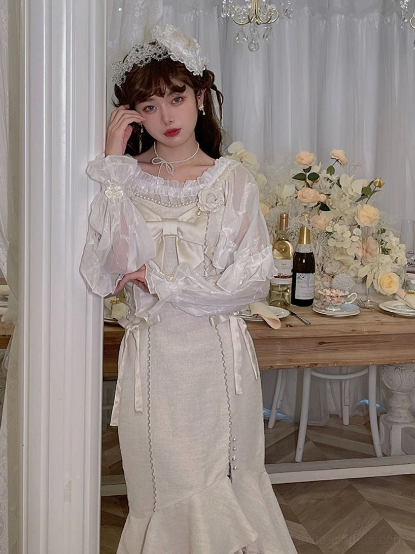 Ivory vintage long-sleeve Lolita dress with ruffled lace collar, front bow details and fishtail midi skirt, sheer long sleeves close-up in vintage dining room with flowers