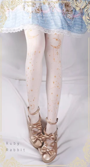 Ivory white velvet Lolita tights with gold foil celestial moon star constellation prints worn by model in sweet Lolita coordinate with light blue dress and gold Mary Jane shoes
