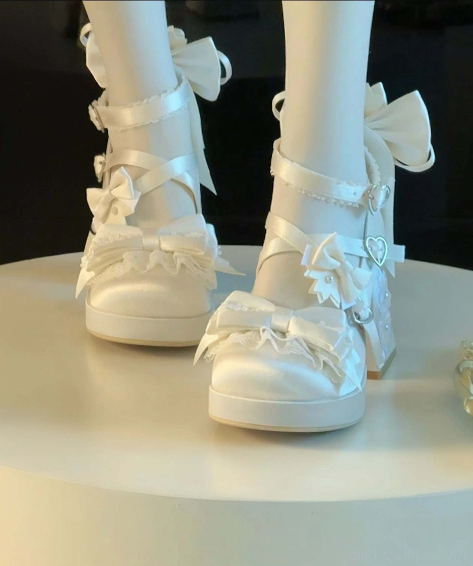 Ivory white sweet lolita chunky platform heel shoes with multi-layer ruffled bows heart-shaped metal buckles and satin fabric showcased on mannequin display stand