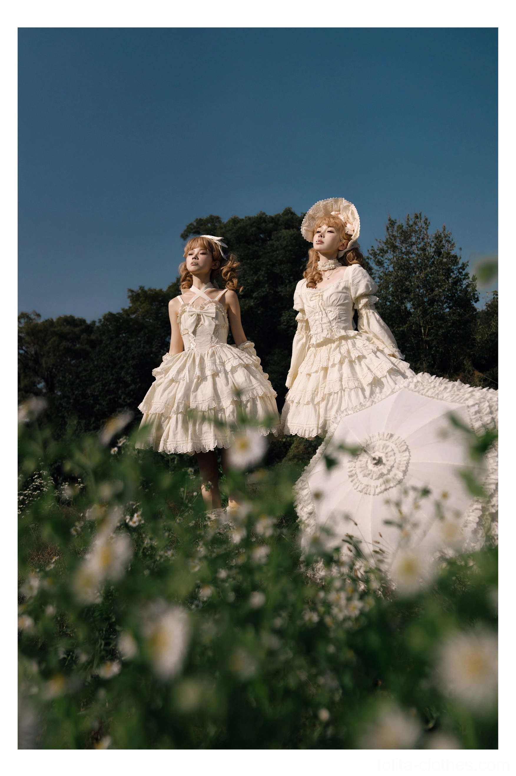 Ivory white sweet lolita one-piece dress set with tiered ruffled skirts, high neckline, classic doll-like bonnets, worn by two models in flower field with lace parasol outdoor props