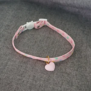 Heart charm choker back view showing gold jump ring attachment and matte pink pendant detail on grey fabric background lolita accessory