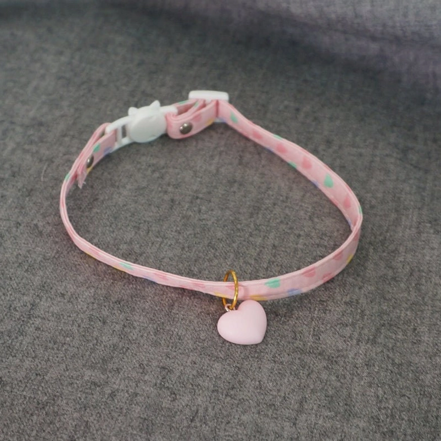 Heart charm choker back view showing gold jump ring attachment and matte pink pendant detail on grey fabric background lolita accessory