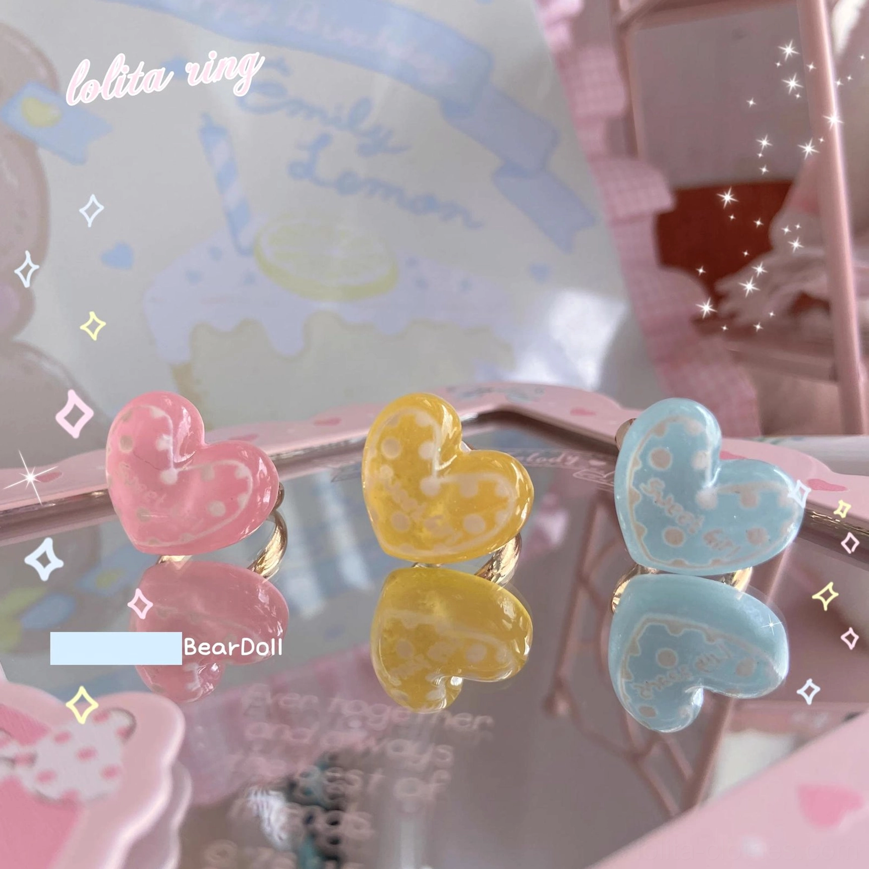 Paired pastel resin heart Lolita rings displayed on pink Lolita-style stand with dessert aesthetic