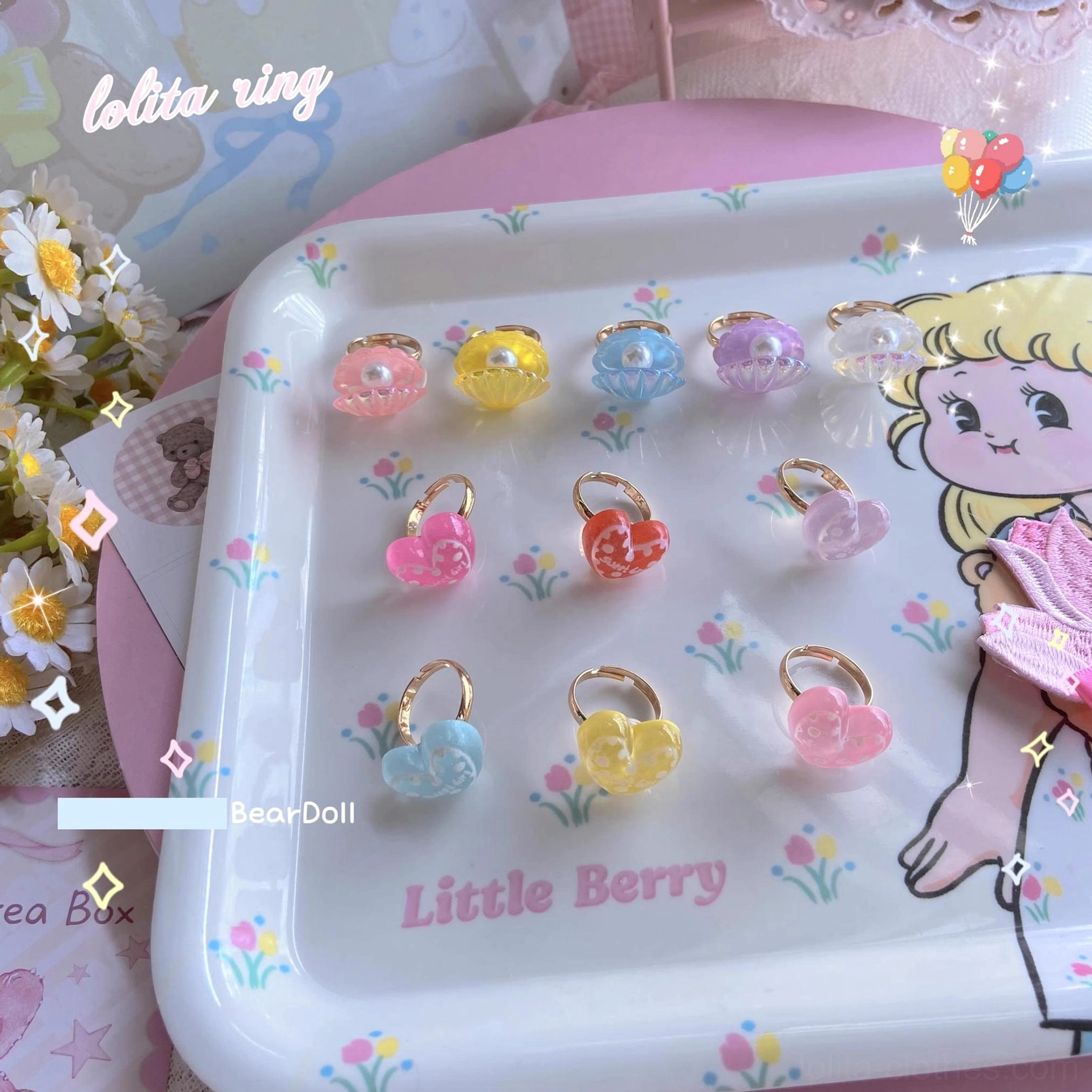 Assorted pastel heart-shaped and seashell resin Lolita ring collection flat lay view cute tray backdrop