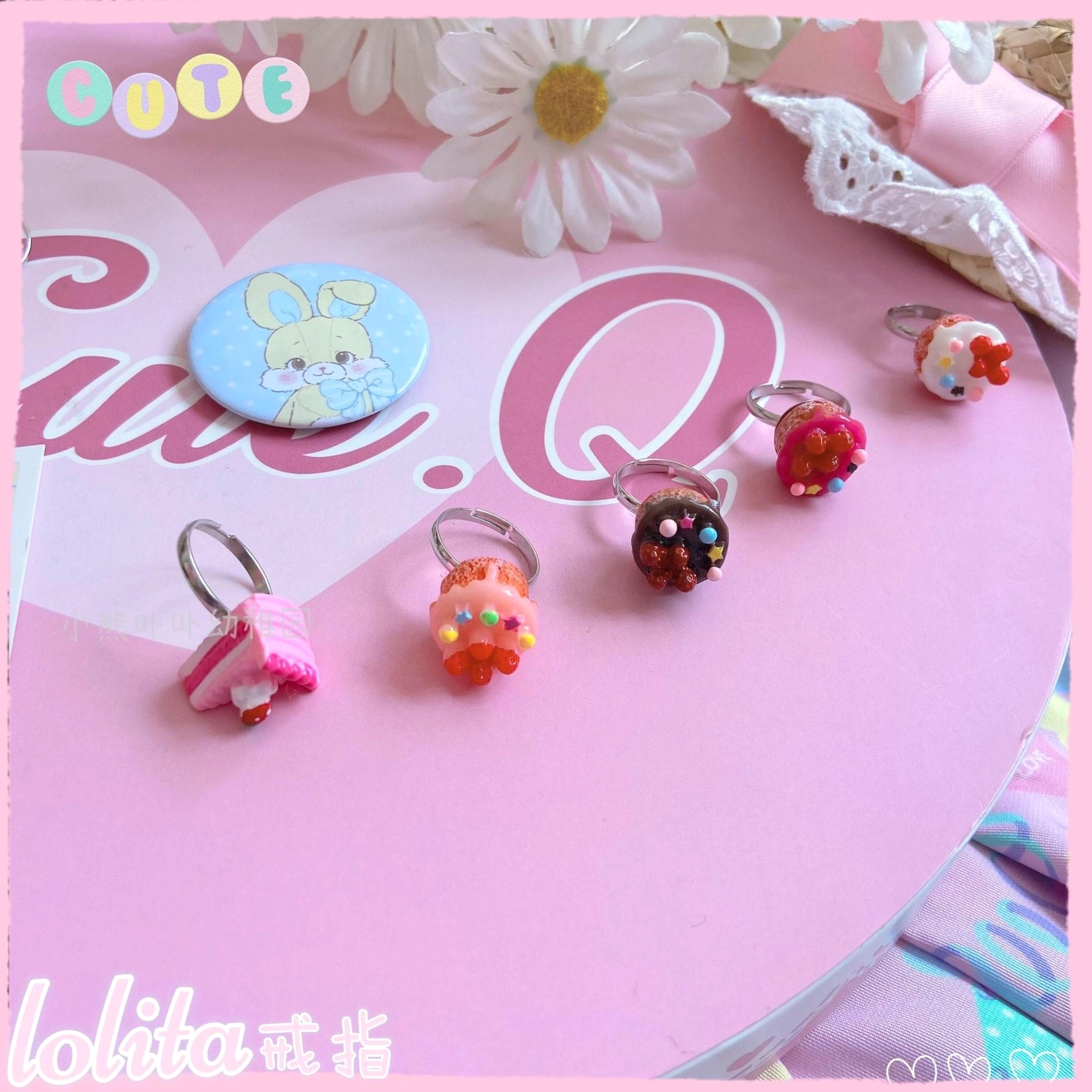 Kawaii miniature cupcake lolita rings styled with lolita fashion accessories on soft pastel pink background