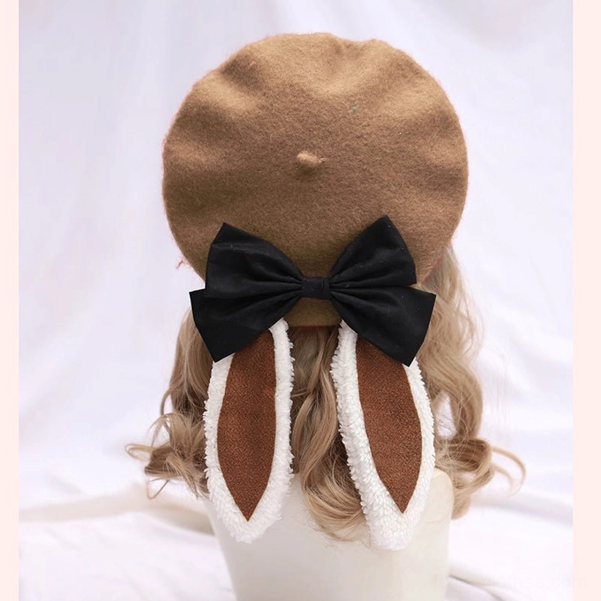 Khaki tan brown lolita beret with white fuzzy trimmed bunny ears and black bow - rear flat lay on mannequin white background