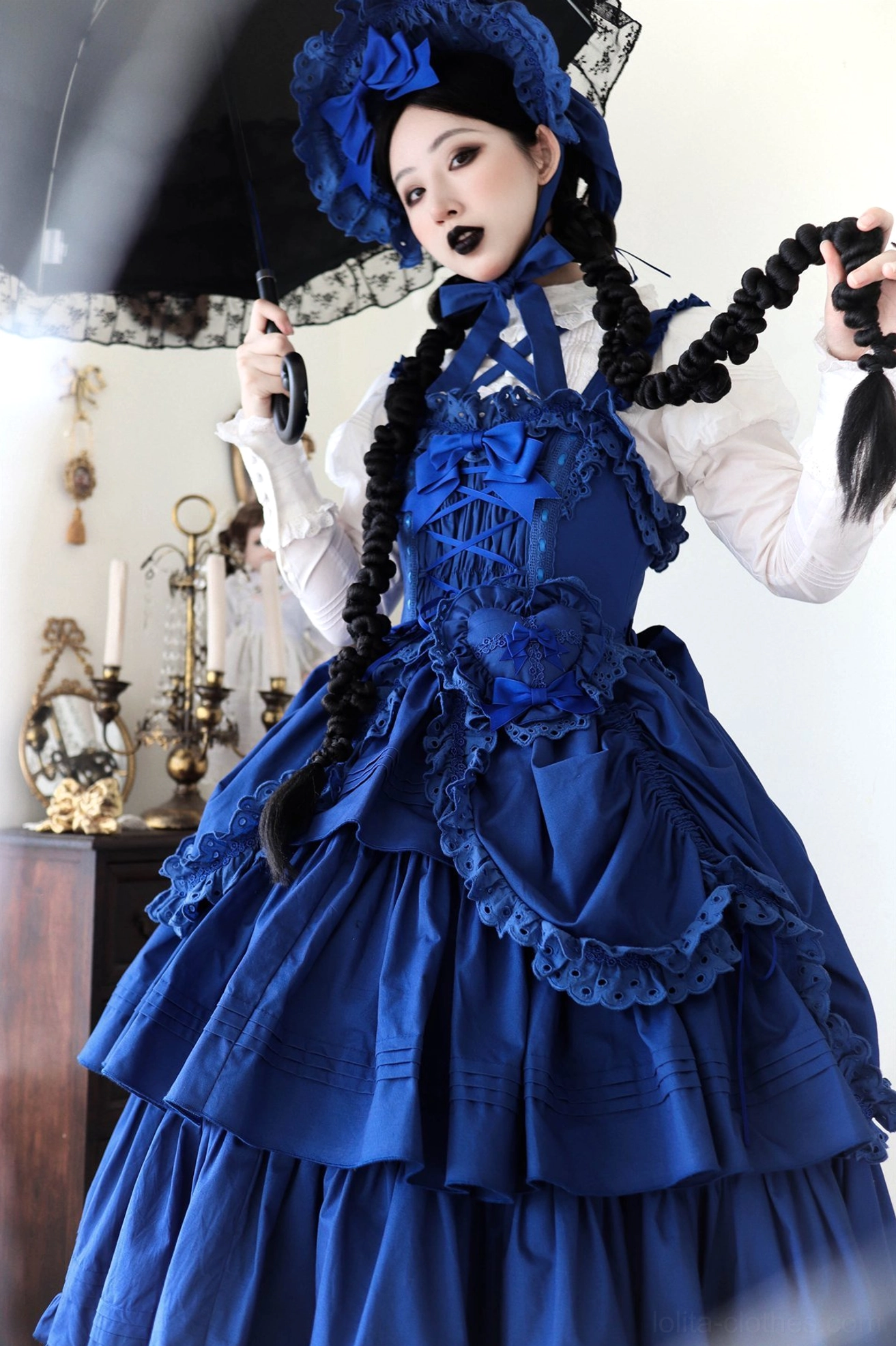 Back view of klein blue Lolita JSK displaying large back bow, back strap design, and layered ruffled hem construction