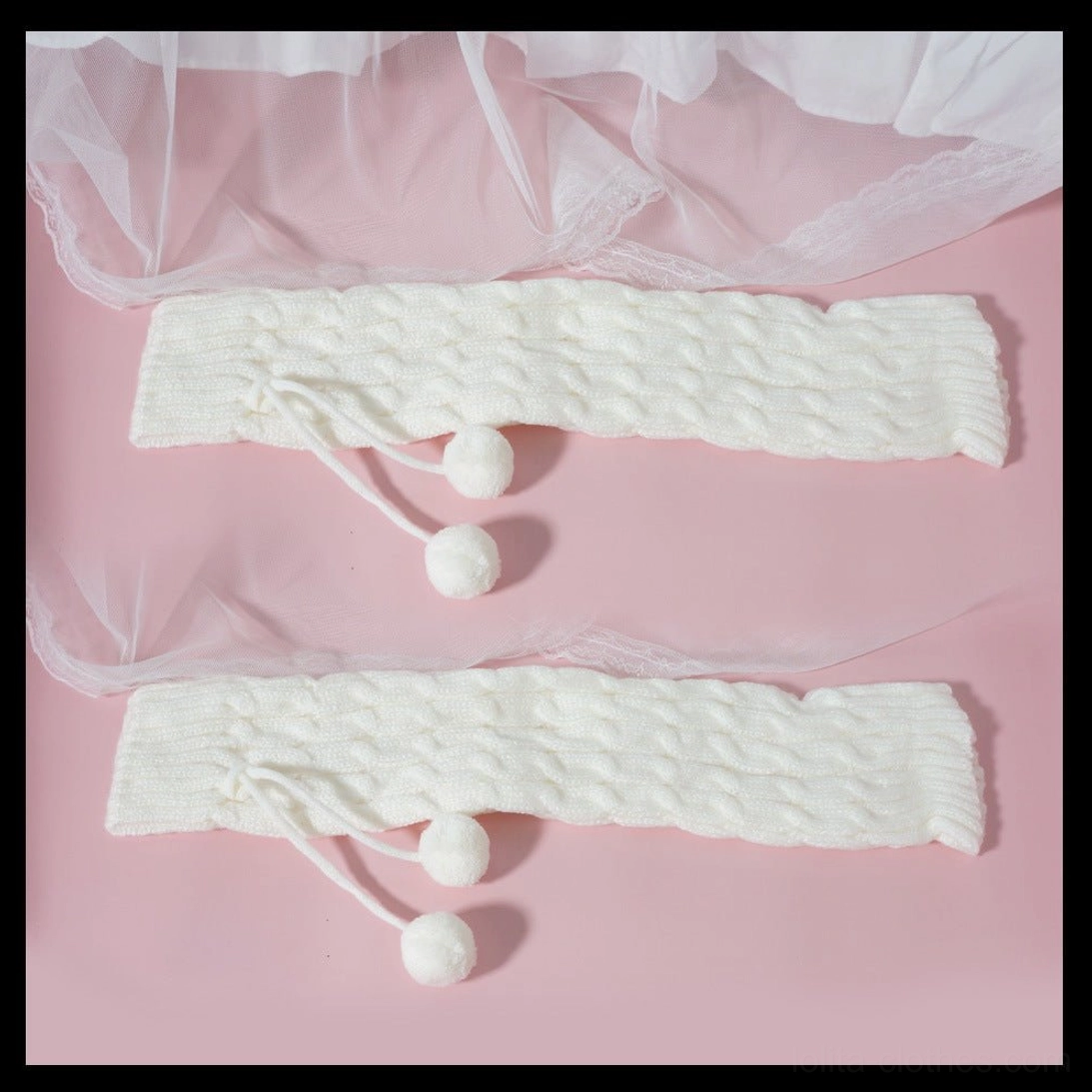 Knitted leg warmers with pom-pom accessories flat lay on pink mesh background off-white cable twisted knit two fuzzy pom-pom charms per pair detachable decorative bows included
