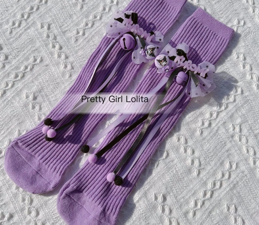 Purple Lolita knee-high socks with Kuromi themed bow and bell decorations long ribbon straps ribbed knit fabric side view
