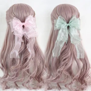 Large dual-color organza bow lolita hair clip displayed on mannequin with light pink wavy hair, showing back view with mint green and light pink sheer fabric and trailing ribbons