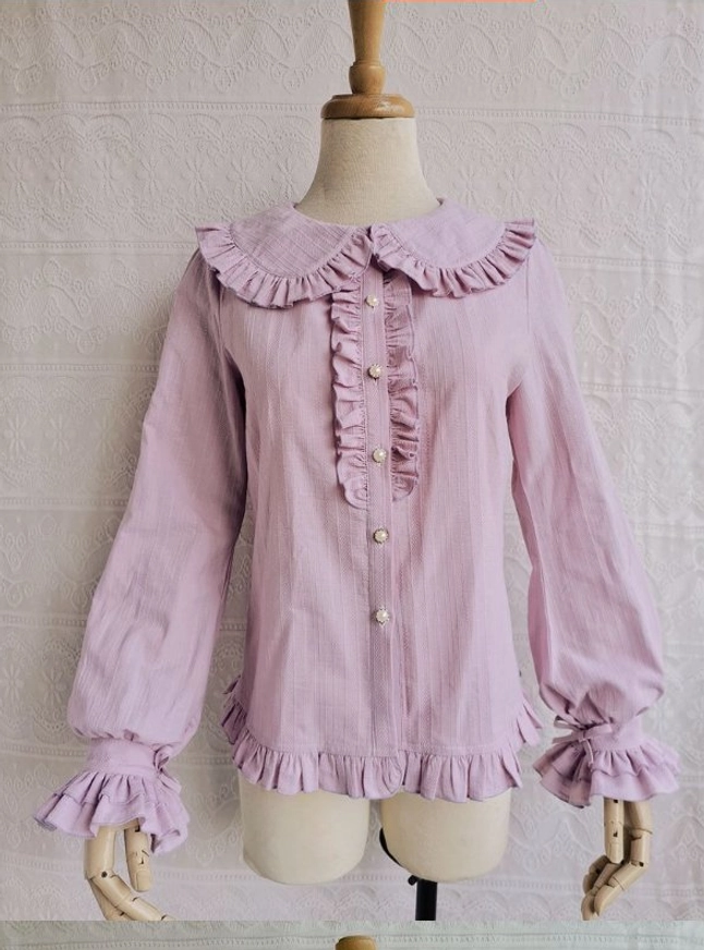 Lavender purple cotton Lolita blouse with ruffled Peter Pan collar pearl button fasteners and ruffled cuffs hem on dress form embroidered backdrop